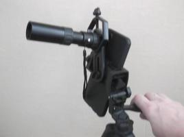 Attachment between monocular telescope and smartphone on a tripod photo