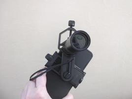 Attachment between monocular telescope and smartphone on a tripod photo