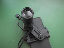 Attachment between monocular telescope and smartphone on a tripod photo