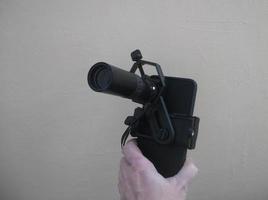 Attachment between monocular telescope and smartphone on a tripod photo