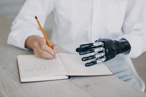 Female makes notes writes in diary, holds notebook using robotic hand. Bionic prosthesis advertising photo