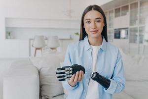 Young girl with prosthetic arm showing high tech bionic prosthesis. Modern people with disabilities photo