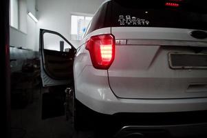 American SUV car on stand for wheels alignment camber check in workshop of service station. photo