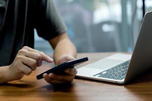 Man hand holding mobile smartphone digital technology network communications at desk. photo