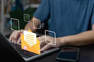 hombre de negocios que usa computadora portátil revisando el icono de correo electrónico en línea o enviando correo a socios y clientes en la web con el concepto de tecnología de interfaz virtual. foto