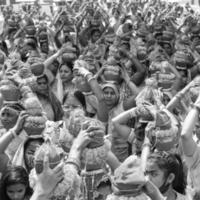 Delhi, India April 03 2022 - Women with Kalash on head during Jagannath Temple Mangal Kalash Yatra, Indian Hindu devotees carry earthen pots containing sacred water with coconut on top-Black and White photo