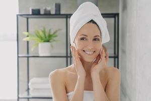mujer feliz limpiando la piel de la cara quitando el maquillaje usando toallitas de algodón después de la ducha. cuidado de la piel, autocuidado