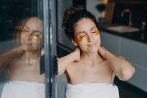 Beautiful woman with under eye patches enjoy morning skincare routine at home. Self love, self-care photo