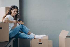 Female selects a mover, relocation service online, using phone apps. Advertising of moving company photo