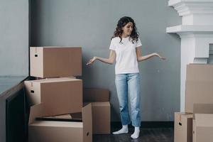 Puzzled girl tenant suffers stress with packing things leaving rented apartment. Hard relocation day