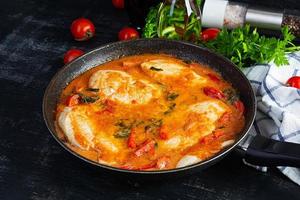 Stew chicken breast with tomato, pepper and spinach in pan photo