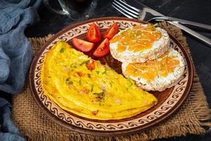 Fried omelette with beef and herbs. Delicious breakfast with eggs, puffed rice cakes and salmon photo