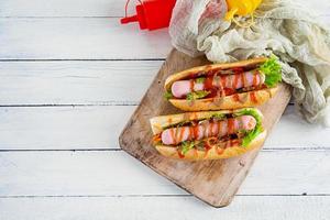 Delicious hot dog with ketchup and mustard on wooden background. Street food photo