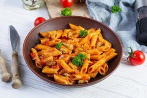 pasta penne en salsa marinara con mejillones, cebolla y perejil. Penne de pasta italiana clásica foto