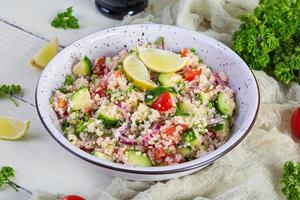 Vegetarian tabbouleh salad with couscous, parsley, cucumber, tomato. Traditional middle eastern or arabic cuisine photo