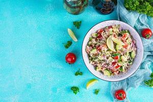 Vegetarian tabbouleh salad with couscous, parsley, cucumber, tomato. Traditional middle eastern or arabic cuisine photo