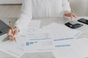 Female business person works calculating project budget, analyzing financial statistics, close-up photo