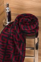 A vertical shot of a patterned red dark blue towel on a rack in a bathroom photo