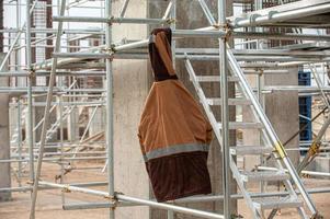 A huge factory construction with stairs and orange special equipment hanging on a stick photo