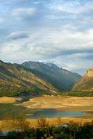 A vertical shot of the mountains and a reservoir in Central Asia photo