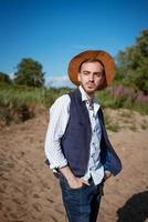 Young man in a hat on nature looks to the side photo