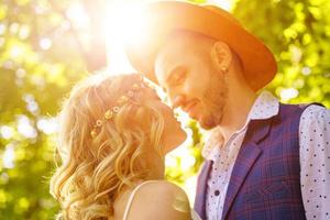 una pareja joven feliz se mira a los ojos en la naturaleza foto