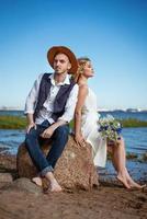 happy couple on the beach with a bouquet of flowers photo