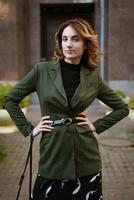 a young woman in stylish clothes poses for the camera on the street photo