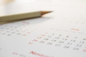 white pencil on calendar background business planning appointment meeting concept photo