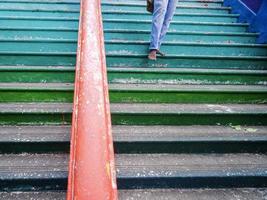 primer plano de un hombre descalzo descendiendo por unos coloridos escalones en las cuevas de batu, malasia foto