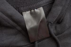 etiqueta de ropa negra en blanco para el cuidado de la ropa sobre fondo de textura de tela negra foto