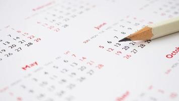 white pencil on calendar background business planning appointment meeting concept photo