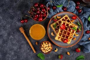 Delicious breakfast with belgian waffles. Waffels with strawberry and berry jam photo