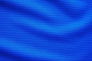 Blue football jersey clothing fabric texture sports wear background, close up top view photo