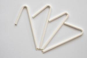 Biodegradable eco friendly white paper drinking straw on white background photo