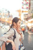 mochila de viajero de mujer asiática adulta joven que viaja en el estilo de vida de la ciudad comida callejera de barrio chino con fondo bokeh. foto