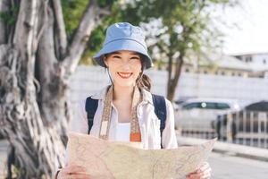 Young adult asian traveller woman in city using maps at outdoor on day. photo