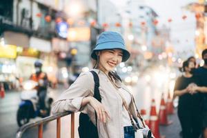 Young adult asian woman traveller backpack traveling in city lifestyle chinatown street food  with bokeh background. photo