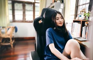 Young adult freelancer asian woman wear headset in workplace space with window light on day photo