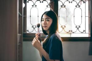 retrato de solo alambiques bienestar mujer adulta joven asiática maquillaje antes del espejo en casa