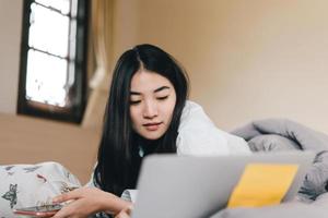 Young adult lonely single woman using laptop computer in the moring for social message app chat with friend photo