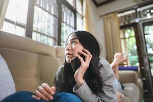 mujer asiática adulta joven que usa teléfono móvil para telemedicina de salud mental. foto