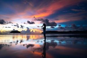 Rear view of adult travel woman relax on beach sand with twilight sunset sky photo