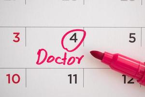 important doctor appointment schedule write on white calendar page date close up photo