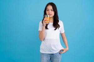 Beautiful woman drinking orange from a glass photo