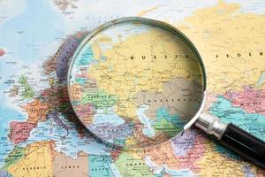 Bangkok, Thailand - May 01, 2022 Russia and Ukraine, Magnifying glass close up with colorful world map photo