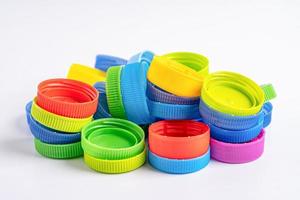 Plastic bottle colored screw caps for recycle waste on white background, container water lid. photo