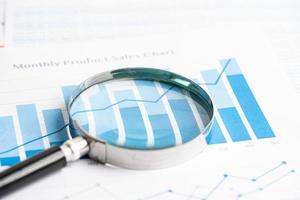 Magnifying glass on chart graph spreadsheet paper. Financial development, Banking Account, Statistics, economy, Stock exchange trading, Business office company meeting concept. photo