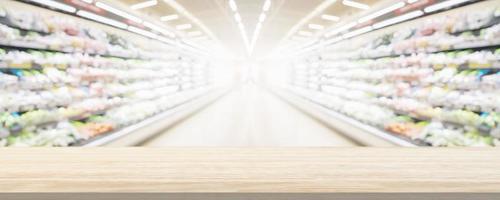 Wood table top with supermarket grocery store blurred background with bokeh light for product display photo