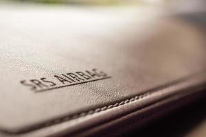 airbag safety sign on brown leather texture in modern car photo